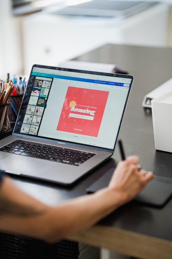 Mastering the First Impression: Your intriguing post title goes here Person using a laptop and graphic tablet for digital design work in a home office.