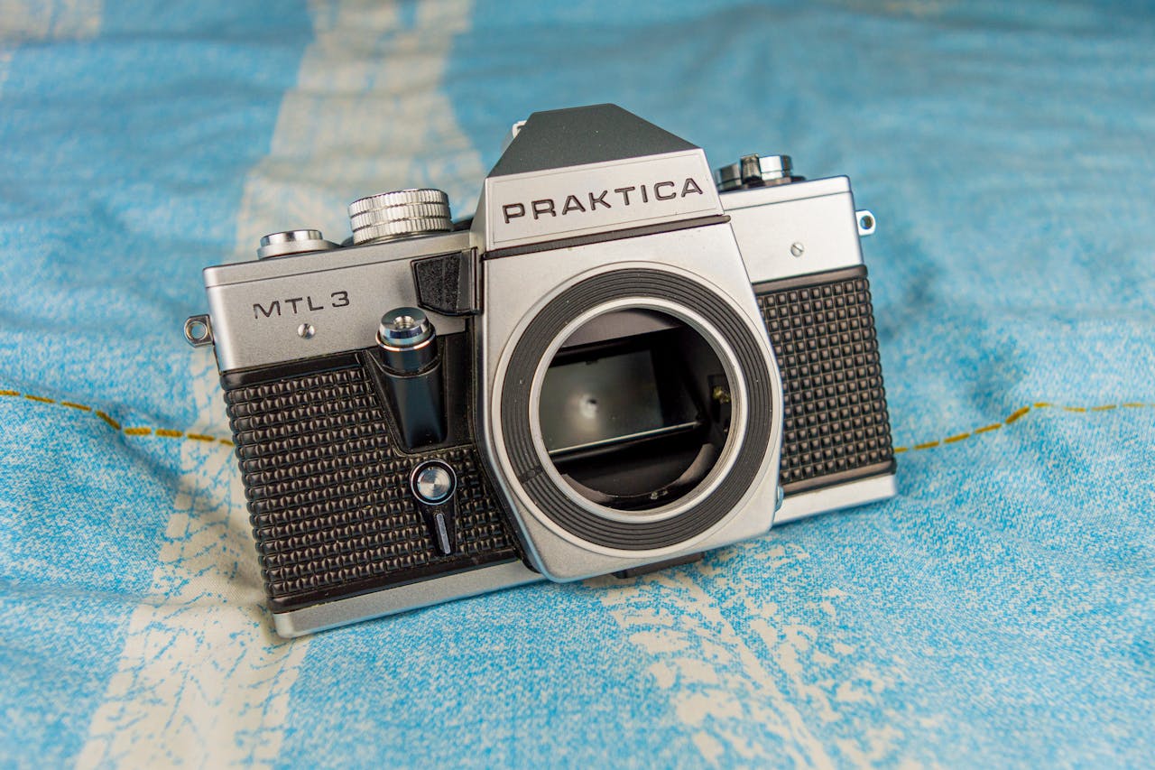 discover Classic Praktica MTL3 film camera placed on a textured blue surface, showcasing retro design.